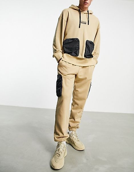 adidas Originals – RYV – Jogginghose in Beige mit Taschen an den Hosenbeine günstig online kaufen