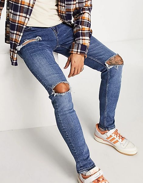 ASOS DESIGN – Enge Jeans mit großen Rissen in verwaschenem Mittelblau günstig online kaufen