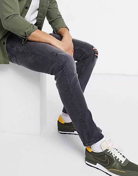 ASOS DESIGN – Schmale Stretch-Jeans in verwaschenem Schwarz mit Riss am Kni günstig online kaufen