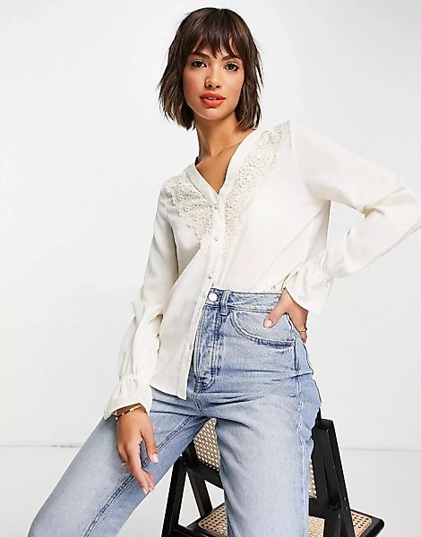 Vero Moda – Bluse in Creme mit V-Ausschnitt, Spitzendetails und elastischen günstig online kaufen