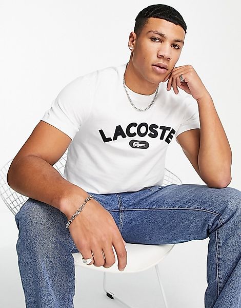 Lacoste – T-Shirt in Weiß mit bogenförmigem, auffälligem Logo günstig online kaufen