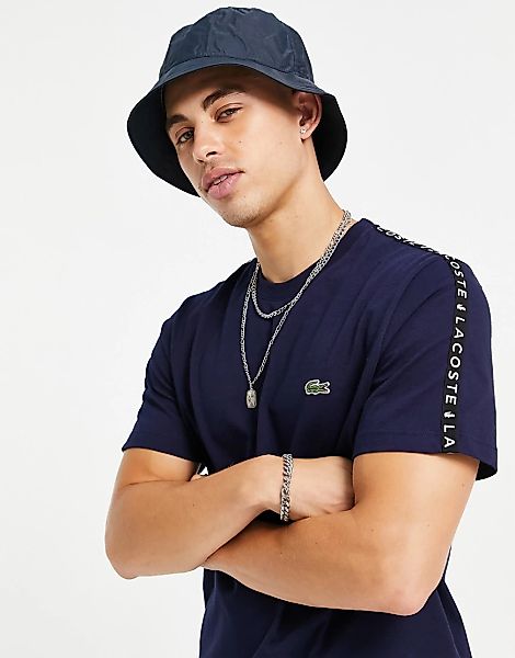 Lacoste – T-Shirt in Marineblau mit Zierstreifen an den Ärmeln günstig online kaufen