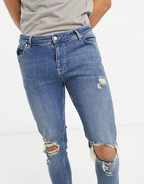 ASOS DESIGN – Enge Jeans mit Used-Design und Zierrissen in mittelblauer Was günstig online kaufen