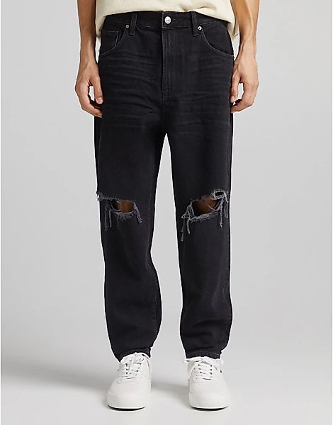 Bershka – Schmal zulaufende Jeans in Schwarz mit Zierrissen günstig online kaufen