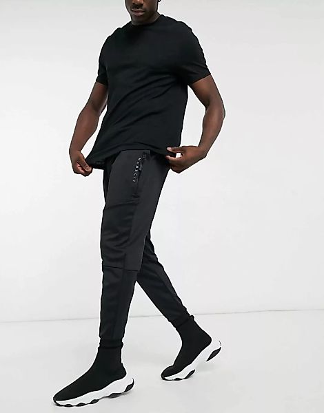 ASOS DESIGN - Schmal zulaufende Jogginghose aus flexiblem Gewebe in Schwarz günstig online kaufen