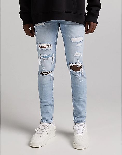 Bershka – Superenge Jeans mit Zierrissen in Blau günstig online kaufen