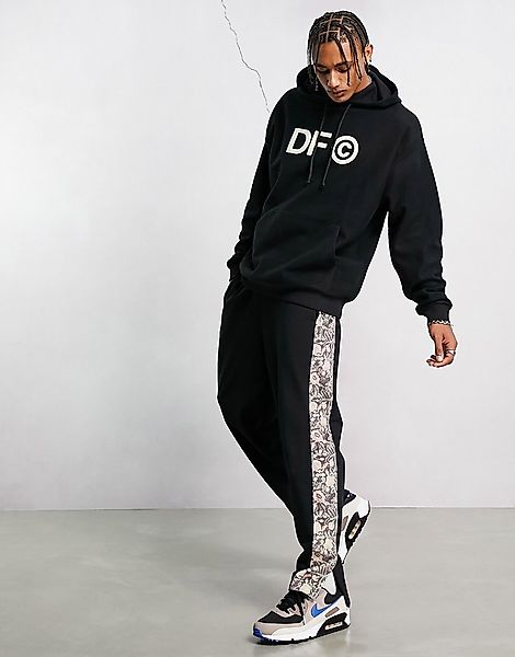 ASOS – Dark Future – Lockere Jogginghose mit Seitenstreifen aus bedrucktem günstig online kaufen