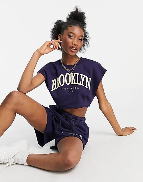 Bershka – Kurz geschnittenes T-Shirt mit „Brooklyn“-Collegeprint in Blau, K günstig online kaufen