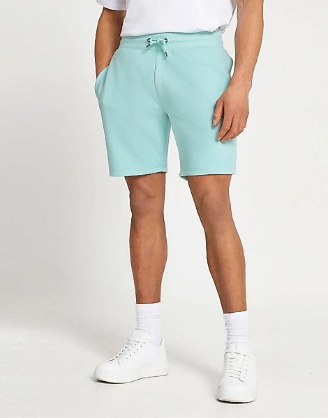 River Island – Schmal geschnittene Jersey-Shorts in Grün mit „RI“-Logo günstig online kaufen