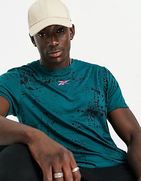 Reebok – T-Shirt in Dunkelgrün mit Ölspritzer-Muster und knalligem rosa Log günstig online kaufen